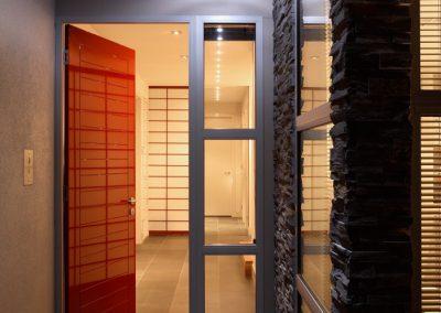 The Entrance To A Modern Home With A Red Shoji Door